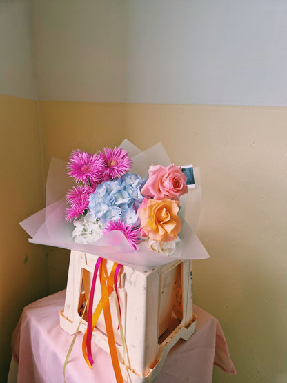 gerbera daisies, hydrangea and rose bouquet in bright colours and ribbon